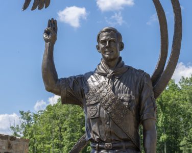 The bronze at the Norman R. Augustine Twelve Points Ceremonial Plaza depicts Eagle Scout Gregory Augustine presenting the Scout sign.
