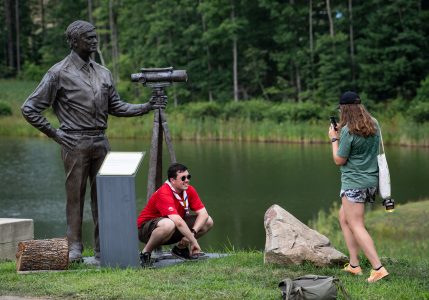 IST staff members pause for photos at the bronze statue of T. Michael Goodrich at Lake Goodrich during the 24th World Scout Jamboree.