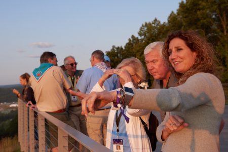 BSA Vice President and Chief Development Officer Chasity McReynolds, right, points out the sights to Lyle and Toril Knight from the deck of WP Point during the 2019 World Scout Jamboree.