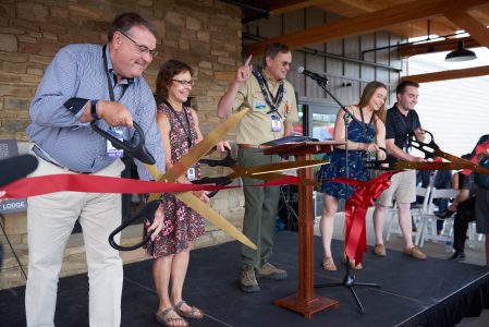 Led by Joe Crafton, center, the Johnson family cuts the ribbon to dedicate Fork in the Road Diner at the 2019 World Scout Jamboree.