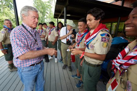 Trevor Rees-Jones shares his commemorative patches with Scouts from Texas at The Rees-Jones Foundation Leadership Veranda during the 2019 World Scout Jamboree.