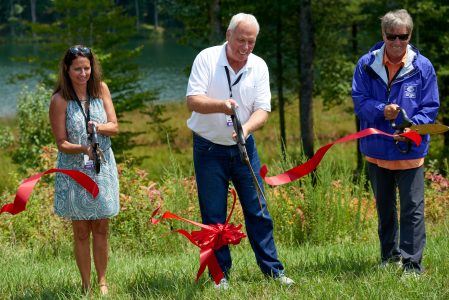 From left, Jamberlyn and Steve Antoliine join Jack Furst in cutting the ribbon to dedicate the Steve Antoline Family Conservation Trail.
