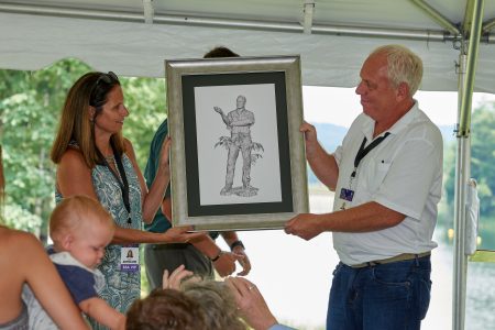 Jamie, left, and Steve Antoline admire a sketch of the Steve Antoline bronze statue during the unveiling ceremony at the 2019 World Scout Jamboree.