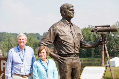 Mike and Gillian Goodrich in front of the Mike Goodrich bronze along the banks of Goodrich Lake