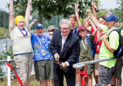 Scouts from across the nation celebrate as Past National President John Gottschalk, center, cuts the ribbon to dedicate John Gottschalk Boardwalk and John Gottschalk Causeway.