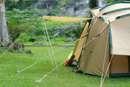 camping tent on waterfall and stream with tree in green jungle or forest for summer winter holiday relax and vacation travel trip with trekking and picnic on lawn or grass at Khlong Nam Lai Waterfall