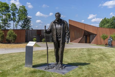 Fenneman Way ends in a cul-de-sac at Perry Park, circling a bronze of Craig Fenneman, with Fenneman Lodge, left, and Fenneman Great Hall.