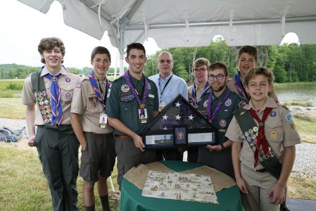 Scouts present Norm Augustine, center, with a flag flown over Norman R. Augustine Twelve Points Ceremonial Plaza.