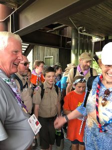 Frank McAllister, left, interacts with visitors to the 2019 World Scout Jamboree as he gives informative, impromptu learning moments at the Sustainability Treehouse.