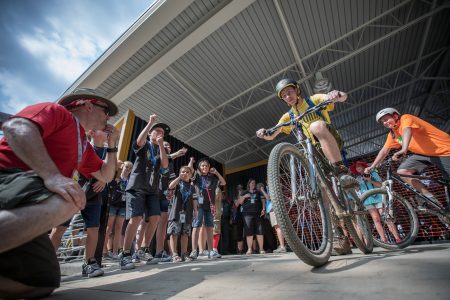 A Scout makes the ceremonial first ride from the launch of the Jared Harvey Mountain Bike Trails at the 2017 National Scout Jamboree.